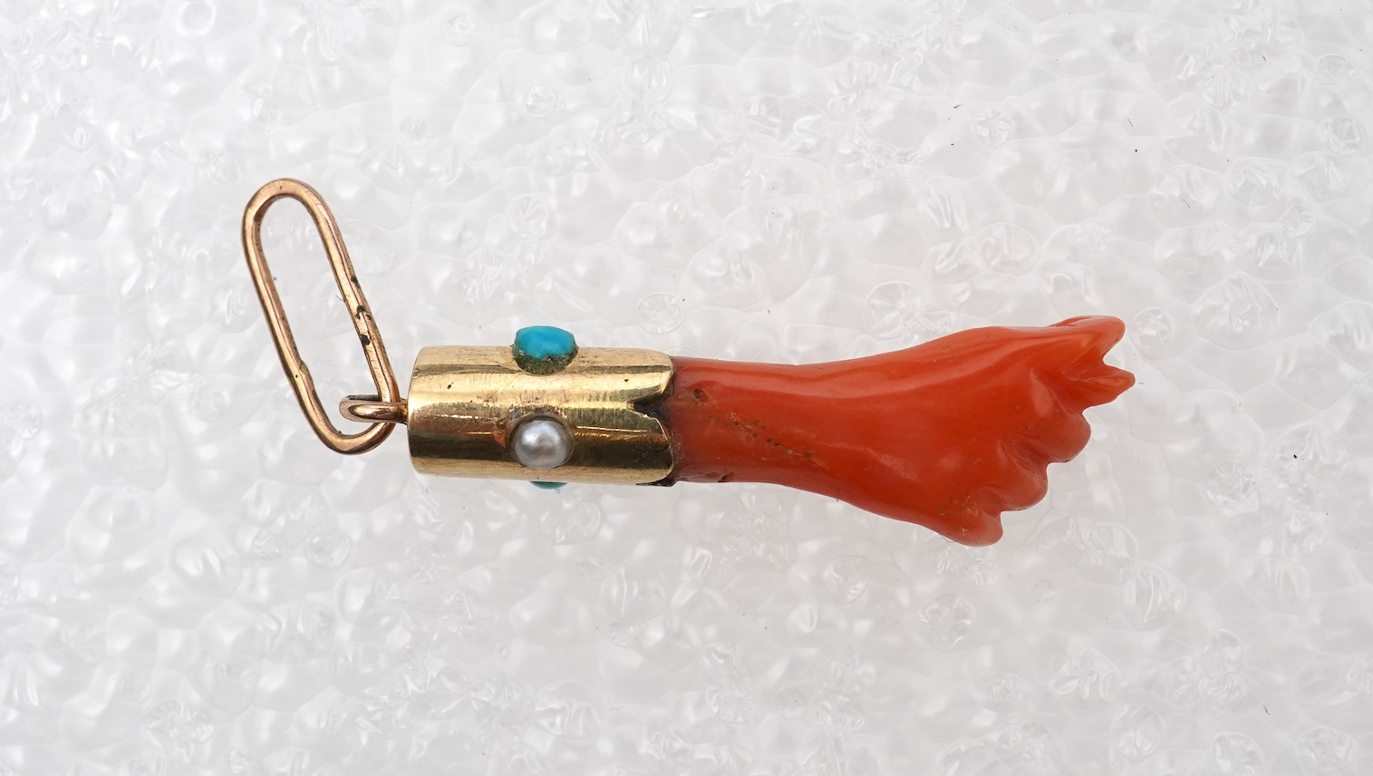 An antique coral, turquoise and seed pearl 'mano figa' pendant, late 19th/early 20th century